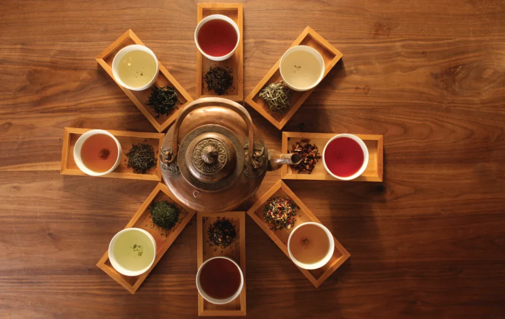 Eight teas around a tea kettle.