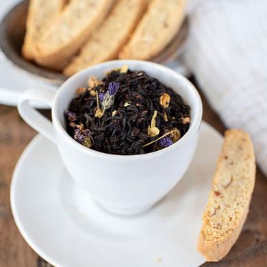 Loose leaf tea in a teacup with snacks on the side